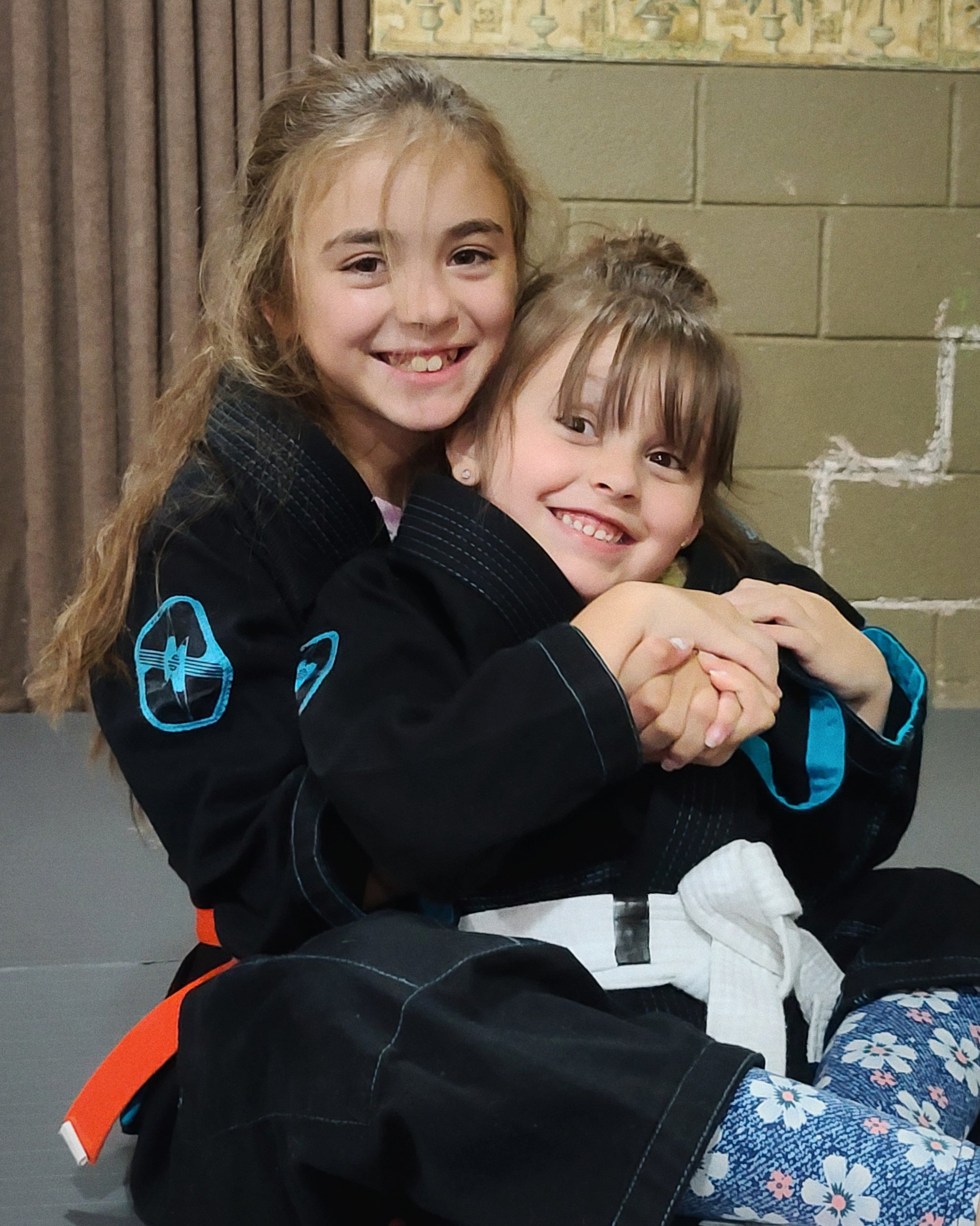 Two female students practicing Brazilian Jiu-Jitsu.